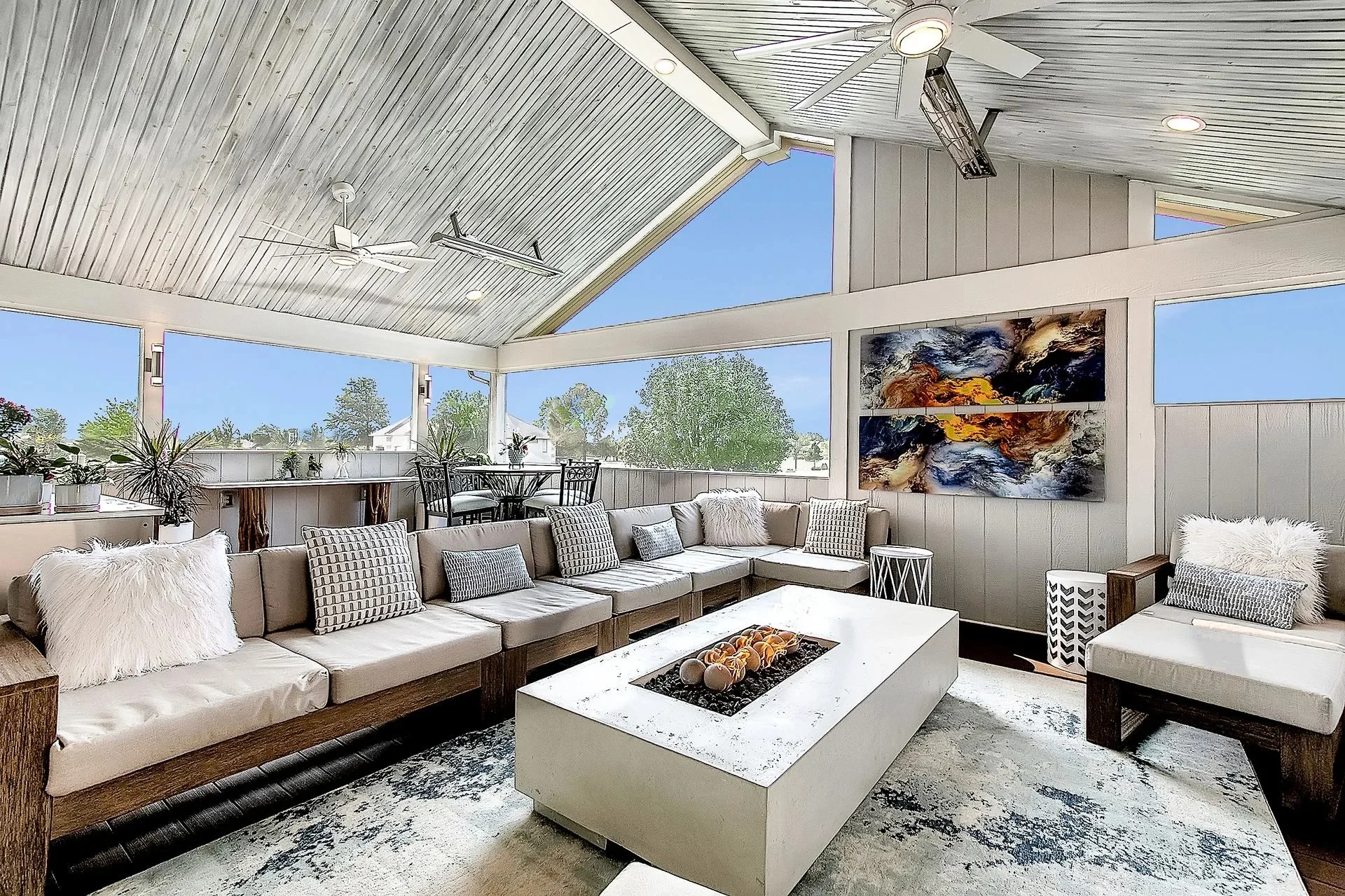 Bright screened-in porch with a large sectional, fire table, and vaulted ceilings. Bright screened-in porch with a large sectional, fire table, and vaulted ceilings.