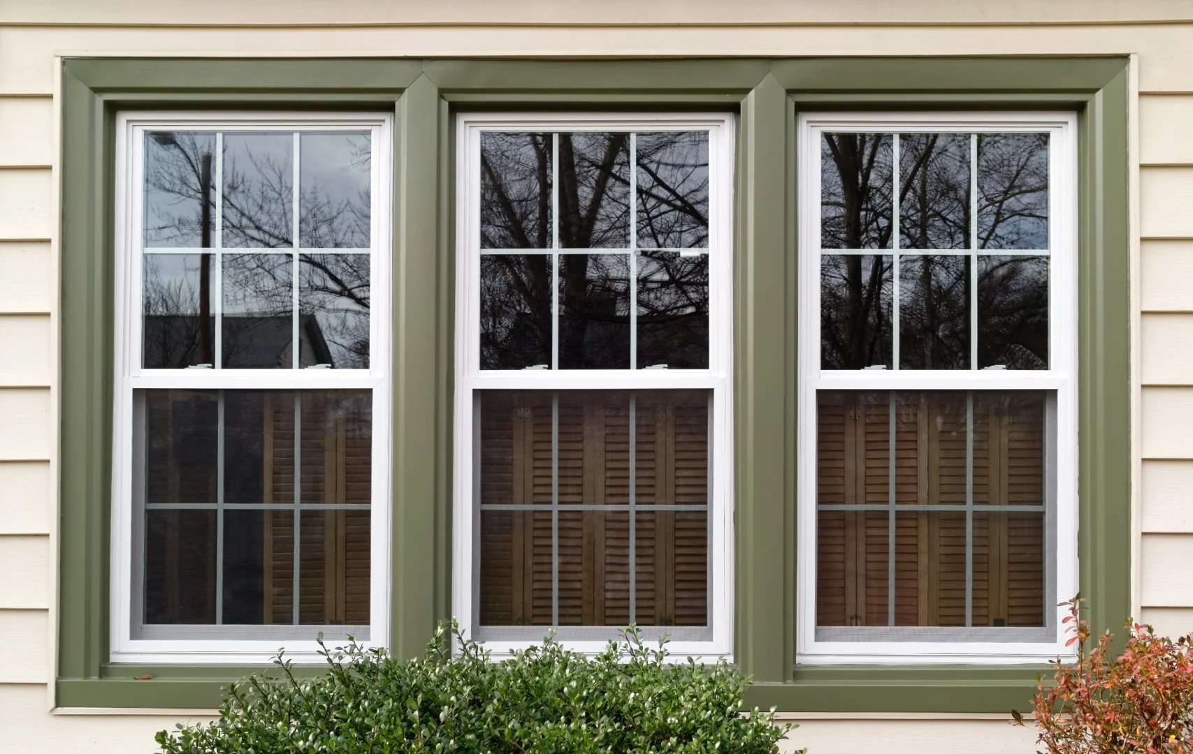 3 double hung windows with green trim